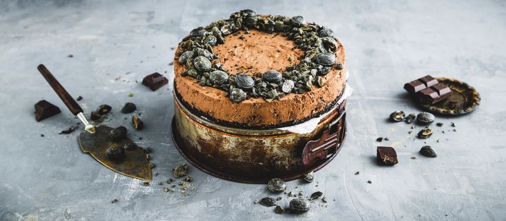 a cake sitting on top of a metal pan covered in chocolate chips and oreos