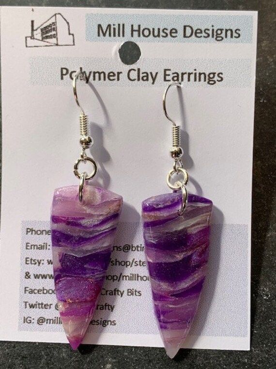 Handcrafted polymer clay earrings. Lightweight and suitable to wear with many different style outfits. The design has been created with translucent clay to make a purple faux crystal  and sealed with resin to protect the surface and add shine Size approximately 3.5x1.5cms. Drop from top of wire 5.5cms Silver plated earring wires  Number 24 purple translucent faux crystal Unique Purple Earrings With Ear Wire, Unique Hand Painted Purple Earrings, Unique Single Purple Earring, Hand Painted Purple Earrings As Gift, Purple Crystal Earrings With Ear Wire As Gift, Handmade Lavender Earrings As Gift, Hand Painted Resin Earrings As Gift, Hand Painted Resin Earrings For Gifts, Handmade Purple Resin Jewelry