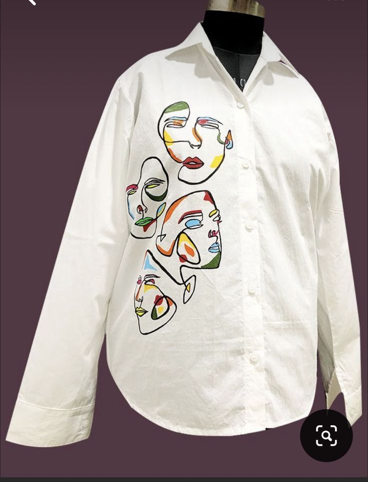 a white shirt with multicolored faces on the front and back, sitting on a mannequin's head