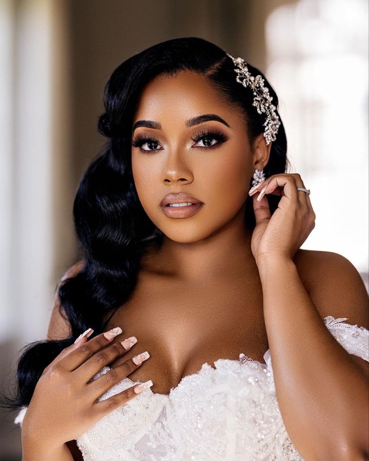 a woman in a wedding dress posing with her hands on her shoulder and wearing a tiara