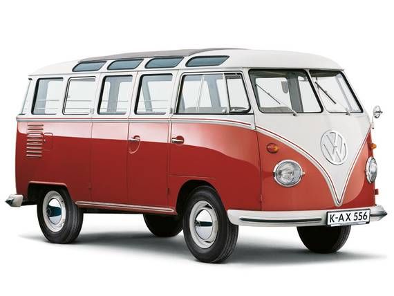 a red and white vw bus parked in front of a gray wall