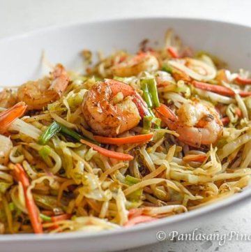 a white bowl filled with noodles and shrimp