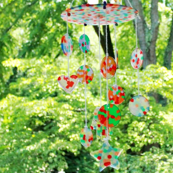 a wind chime hanging in the middle of a forest with lots of green trees