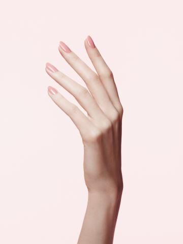 a woman's hand with pink nail polish on it