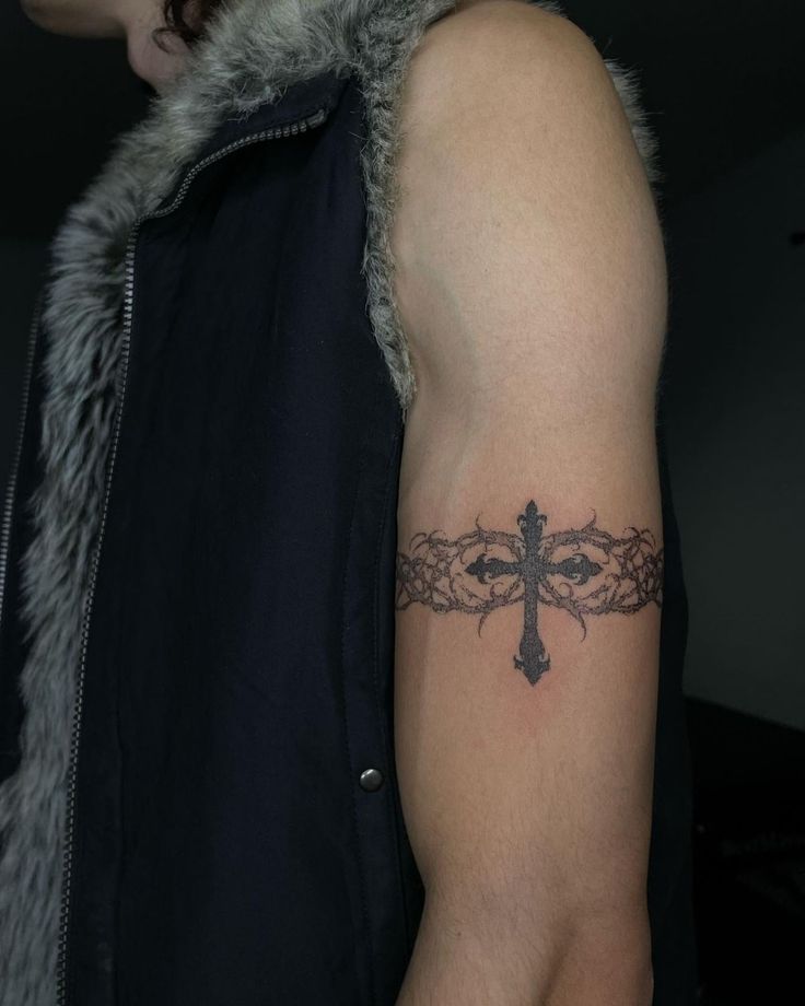 a cross tattoo on the left arm