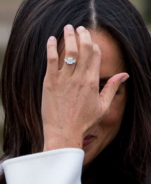 a close up of a person holding their hand to her face while wearing a ring