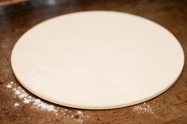 a round pizza dough sitting on top of a wooden table