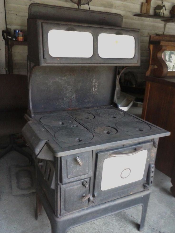 an old fashioned stove with two burners in a room filled with other furniture and items