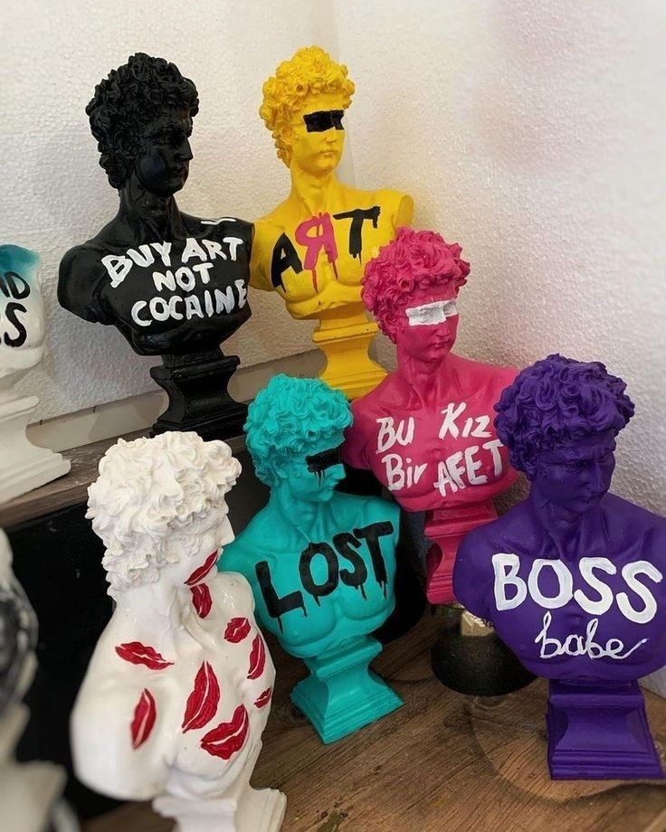 a group of different colored vases sitting on top of a wooden table