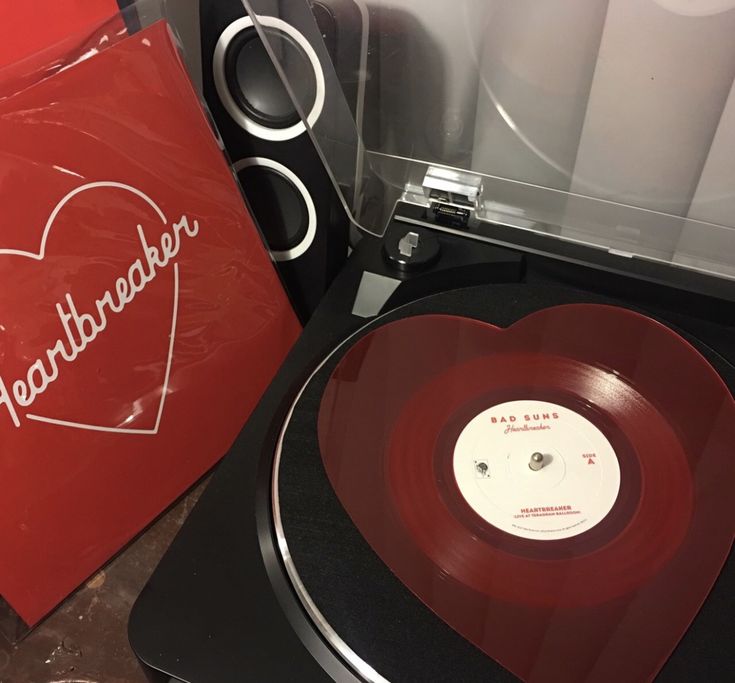 an old record player with a red heart on it and a box next to it