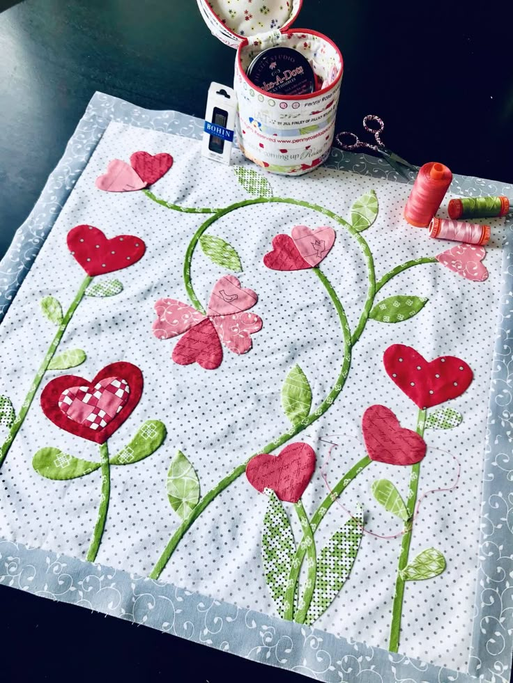 a close up of a piece of cloth on a table with some scissors and thread