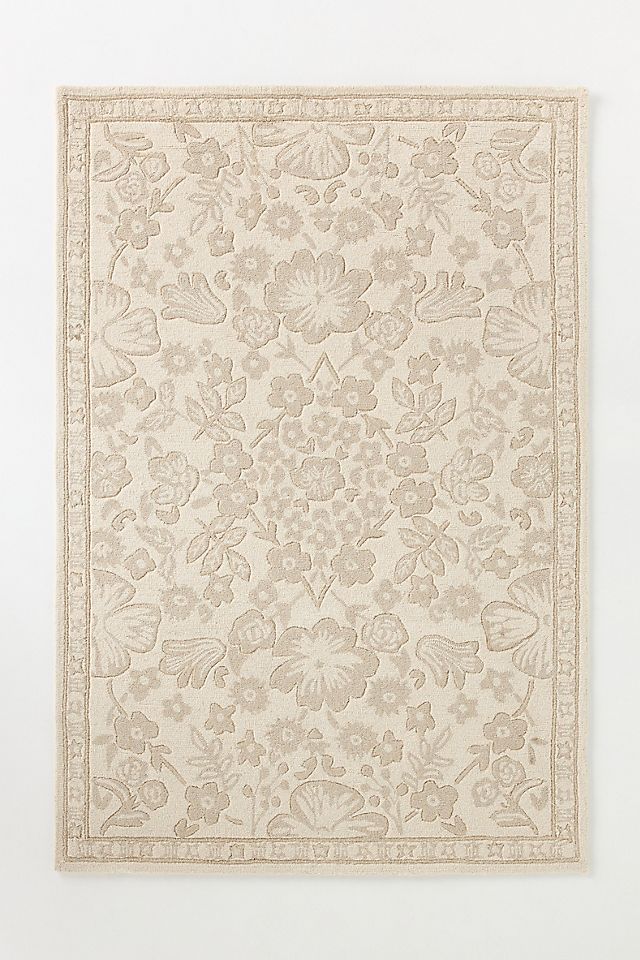 a white rug with flowers and leaves on it