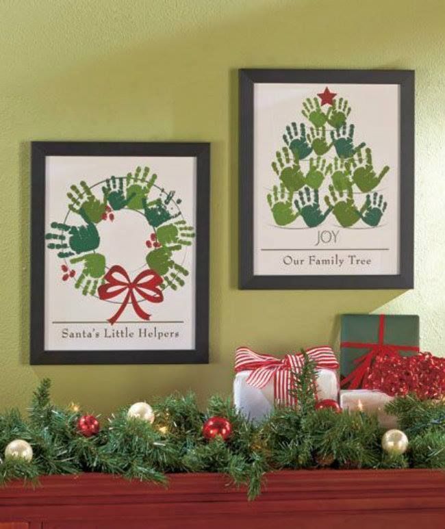 two christmas pictures hanging on the wall above a mantel decorated with greenery and handprints