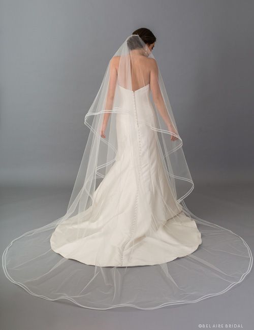 the back of a bride's wedding dress, with her veil draped over it