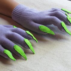 two pairs of purple gloves with green leaves on the fingers and one pair of gray gloves