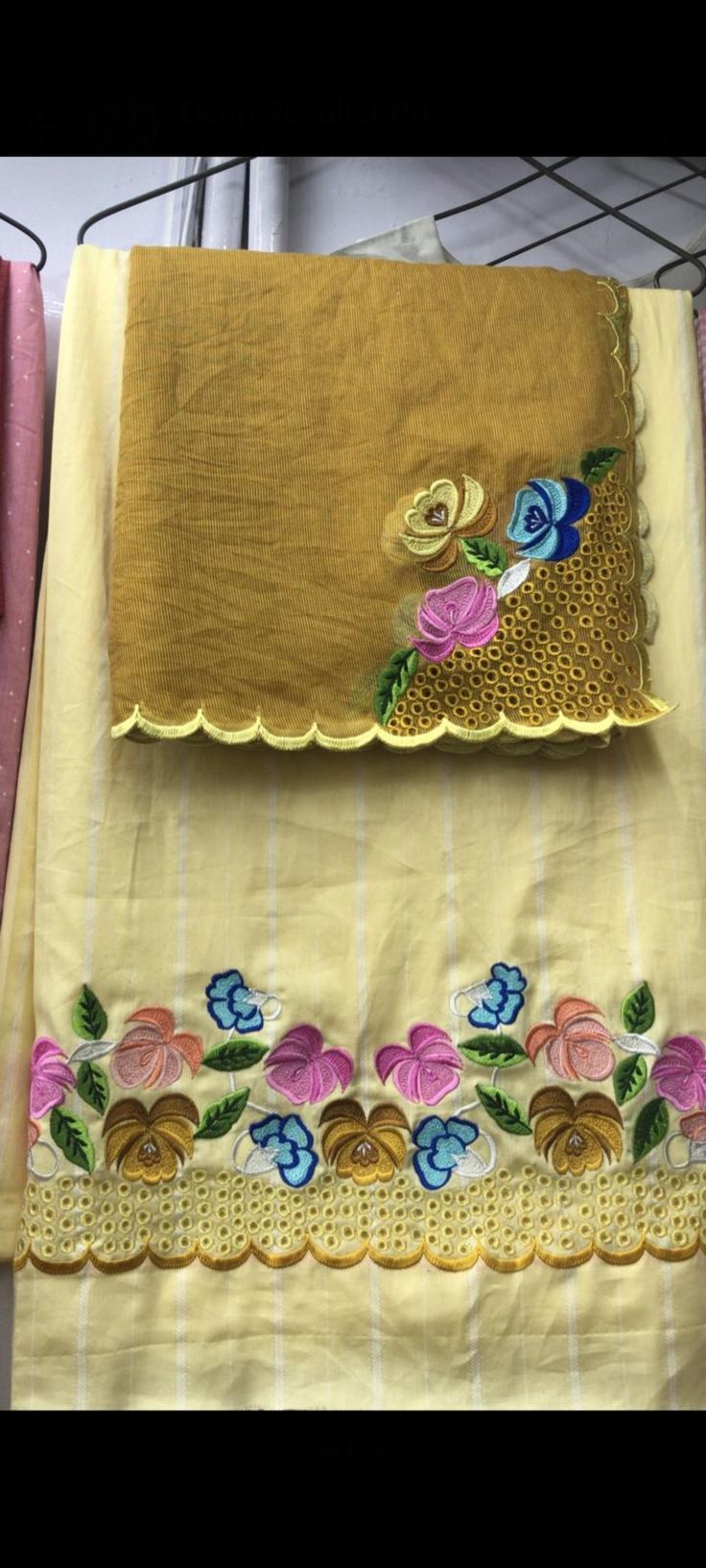 two pieces of yellow cloth with flowers on them, one is folded and the other has an embroidered border