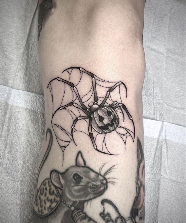 a tattoo on the leg of a person with a mouse and spider web