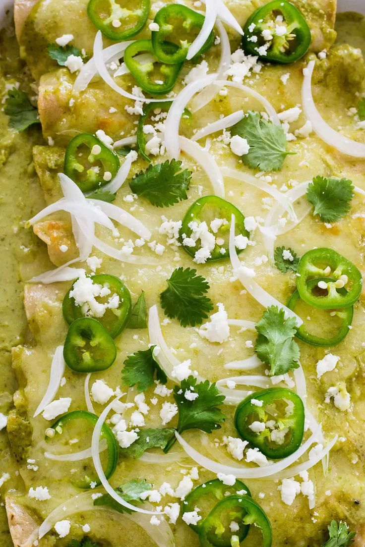 an enchilada topped with green peppers and onions