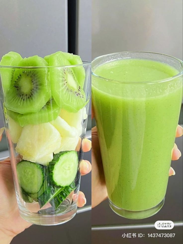 a person holding up a glass filled with green smoothie and sliced kiwis