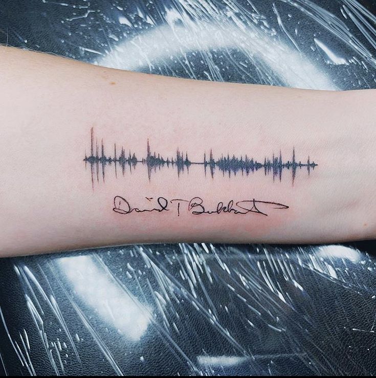 a person's arm with a sound wave tattoo on it