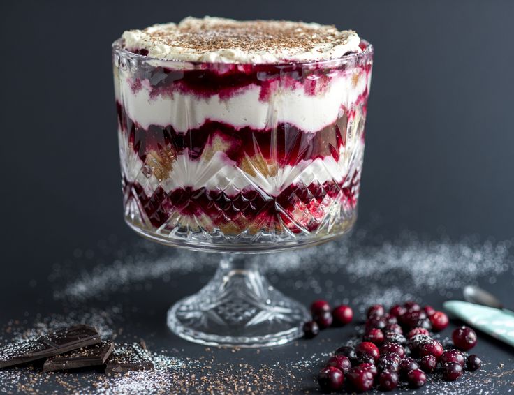 a dessert with cranberry sauce and whipped cream in it on a glass dish