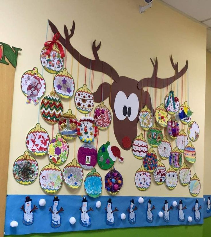 a bulletin board decorated with christmas ornaments and a reindeer's head hanging on the wall