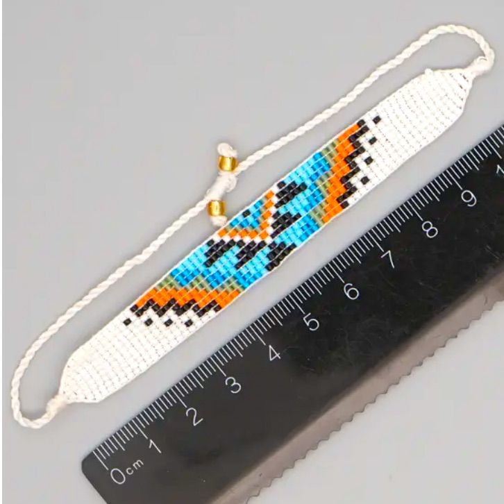 the beaded bracelet is next to a ruler