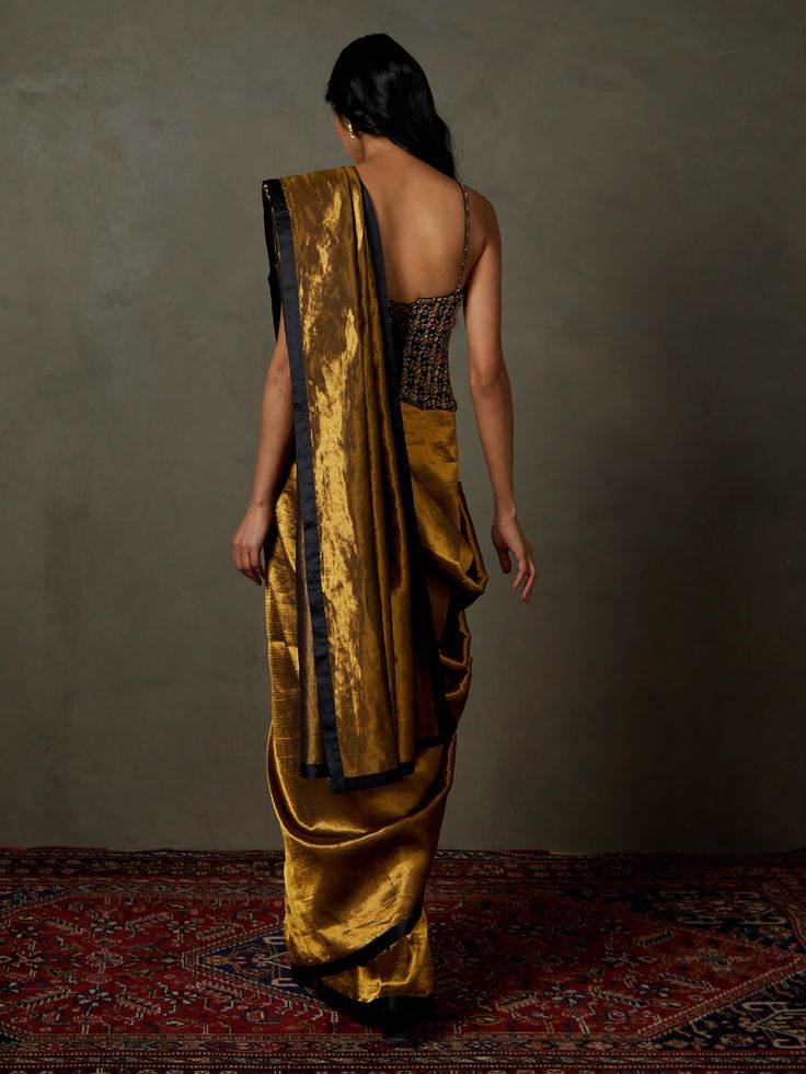 Editor's Note Dazzle in our black/gold zardozi with sootha begum sari, complete with a stitched blouse. This ensemble exudes opulence and style, making it an ideal choice for special occasions and events where you want to stand out with grace and sophistication. The intricate zardozi embroidery and the rich color combination ensure you make a lasting impression with this exquisite attire. Fabric: Begum silk with zari Color: Black, gold Components: Sari and blouse Occasion: Engagement Note: Produ Brocade Pre-draped Saree With Resham Embroidery, Gold Brocade Pre-draped Saree With Zari Weaving, Gold Brocade Pre-draped Saree With Zari Work, Silk Pre-draped Saree With Zari Work For Formal Occasions, Elegant Chanderi Pre-draped Saree For Evening, Formal Silk Pre-draped Saree With Zari Work, Fitted Raw Silk Pre-draped Saree For Evening, Bollywood Style Gold Pre-draped Saree With Pallu, Elegant Fitted Raw Silk Pre-draped Saree