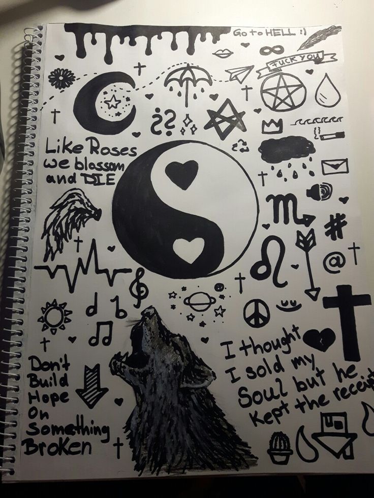 a spiral notebook with black and white drawings on it, including symbols such as the letter s