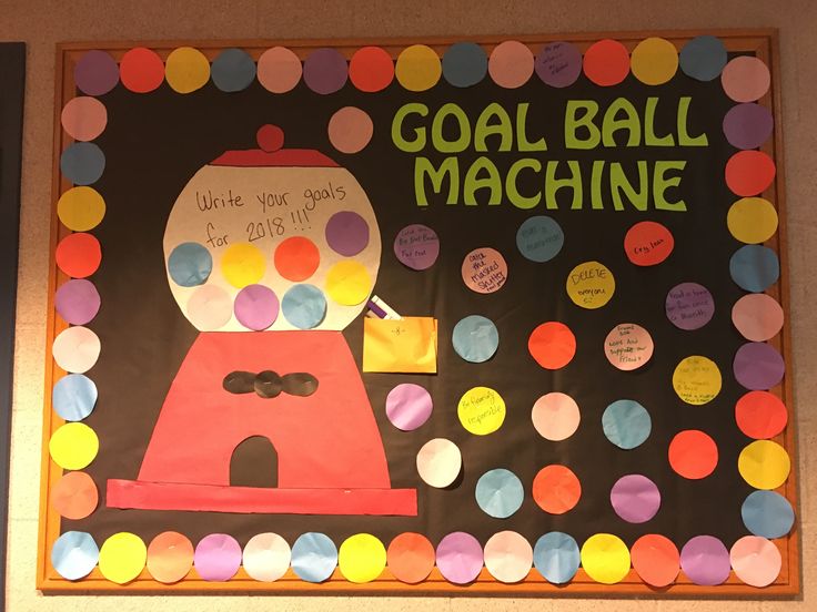 a bulletin board decorated with paper circles and a gumball machine on it's side