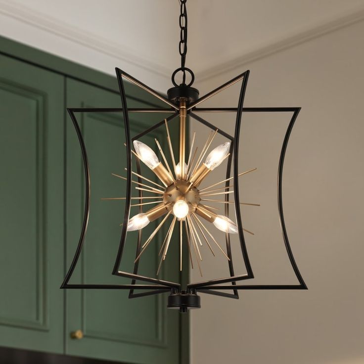 a chandelier hanging from the ceiling in a room with green cabinets and cupboards