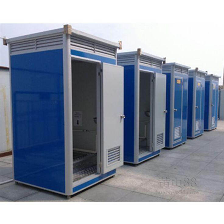 several portable toilets are lined up in a row on the sidewalk, with doors open