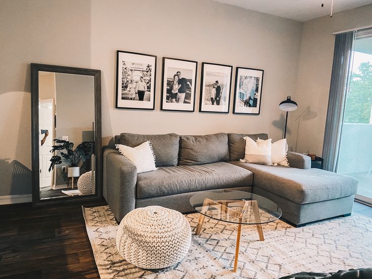 a living room filled with furniture and pictures on the wall next to a large window