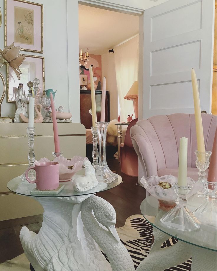 a living room filled with lots of furniture and candles on top of glass table tops