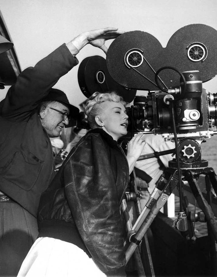 an old black and white photo of a woman on the set of a movie with a camera