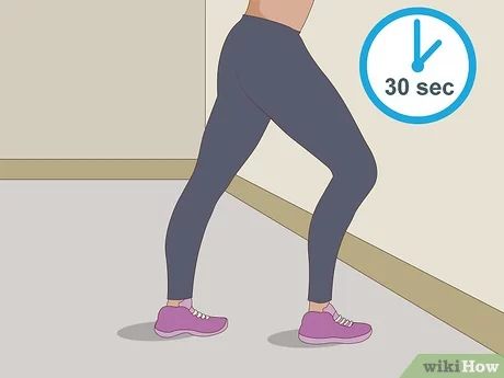 a woman doing squats on the floor in front of a wall with an arrow pointing to