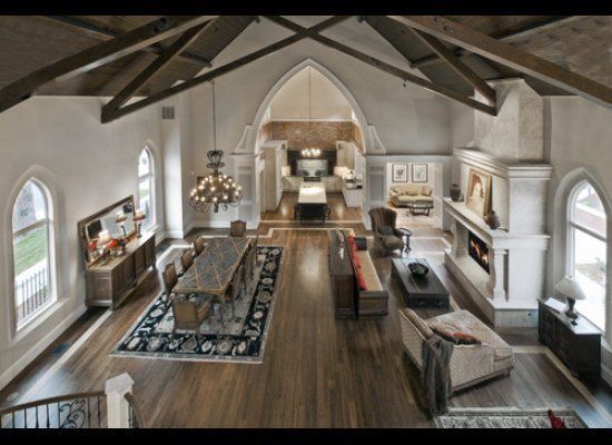 an aerial view of a living room with wood floors and vaulted ceilings, along with arched windows