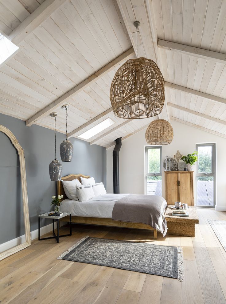 a bedroom with wood floors, white walls and a bed in the middle of the room