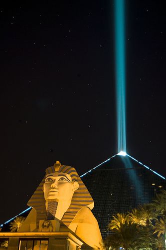 an image of the light show in the night sky over egyptian statues and pyramids