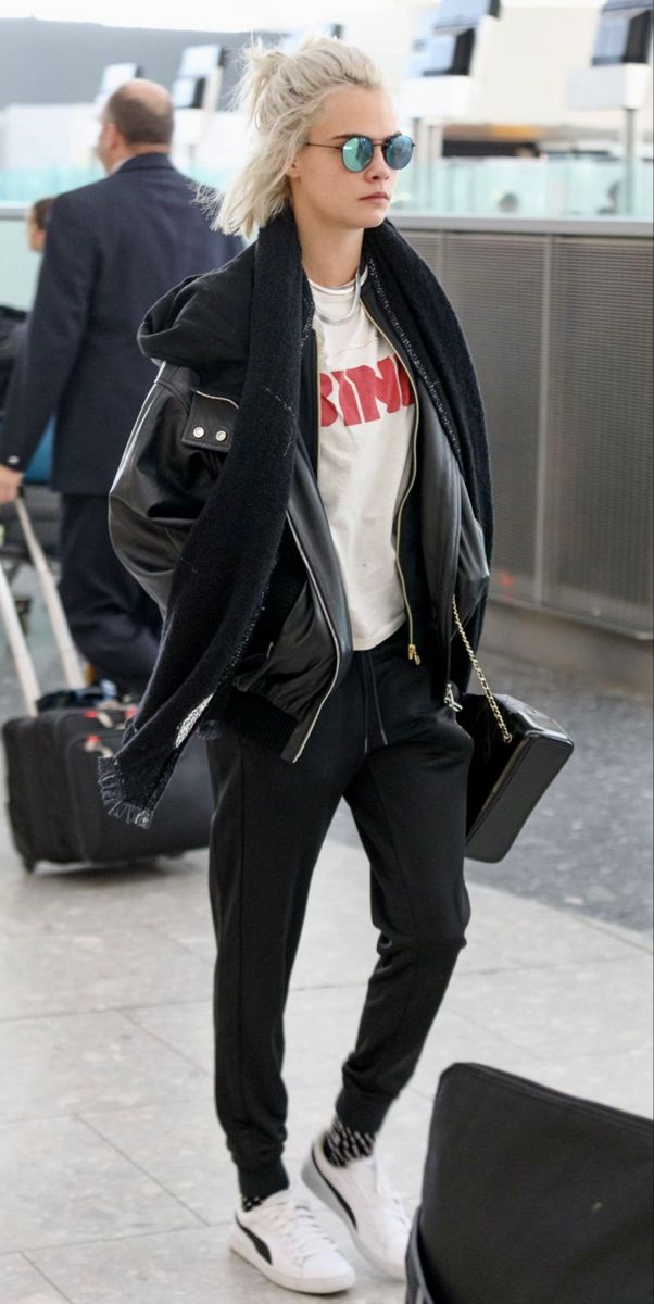 a woman with blonde hair and sunglasses walking through an airport