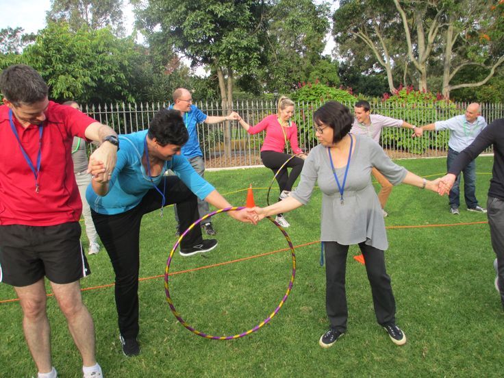 a group of people are playing with hoop tossers on the grass in a park