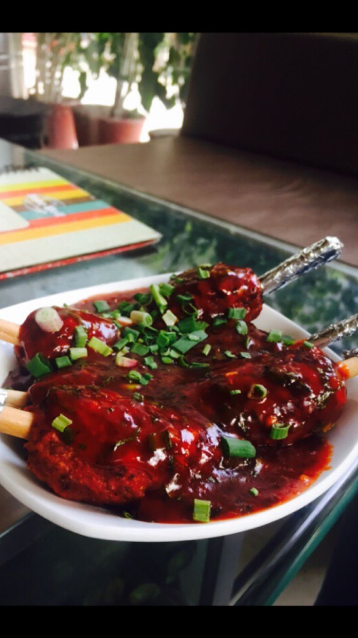 a white plate topped with meat covered in sauce