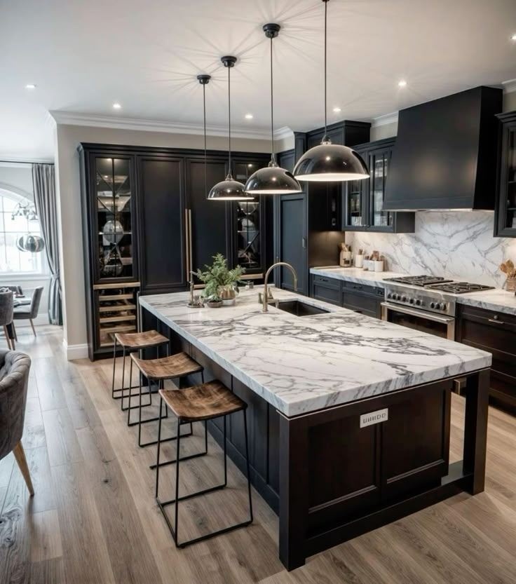 a large kitchen with marble counter tops and black cabinets