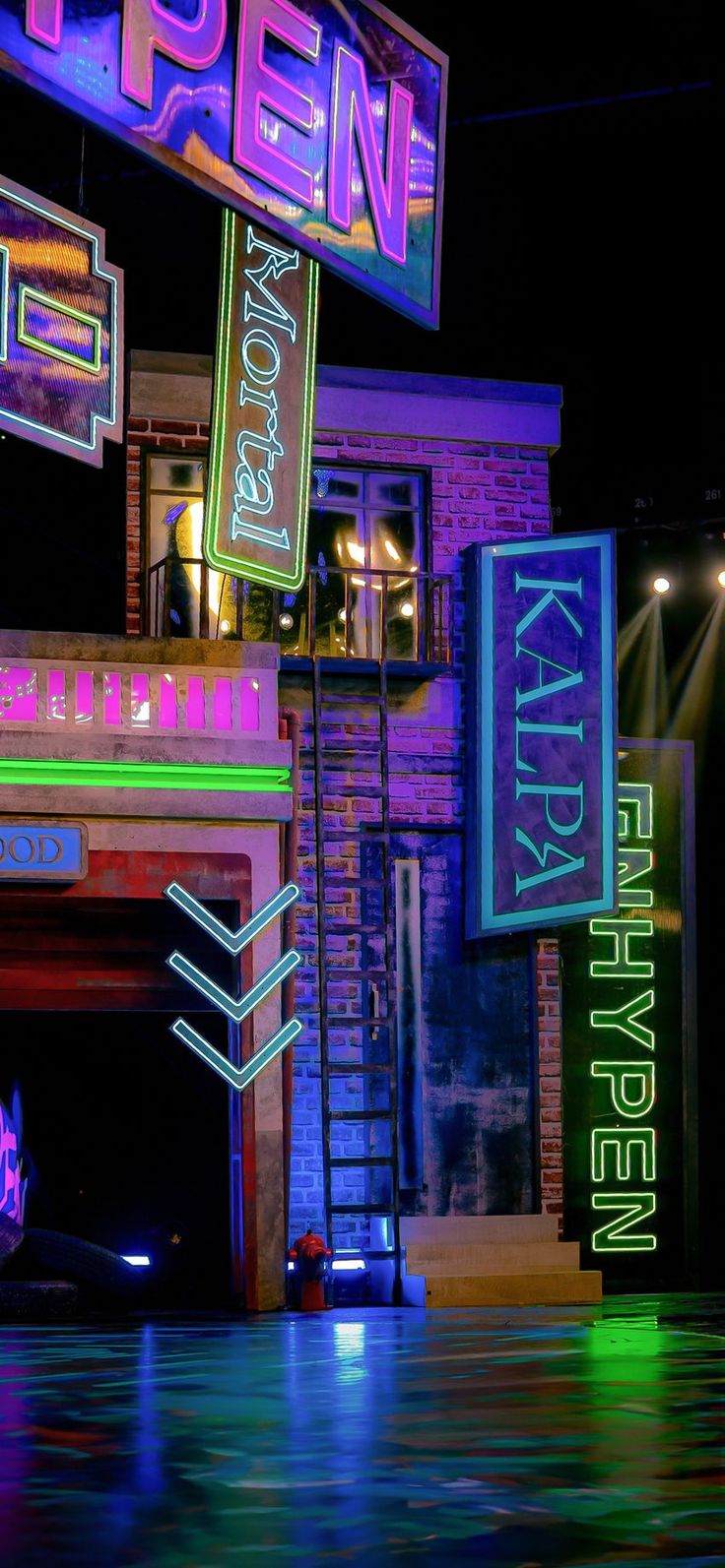 neon signs are lit up at night in front of a brick building with an open sign