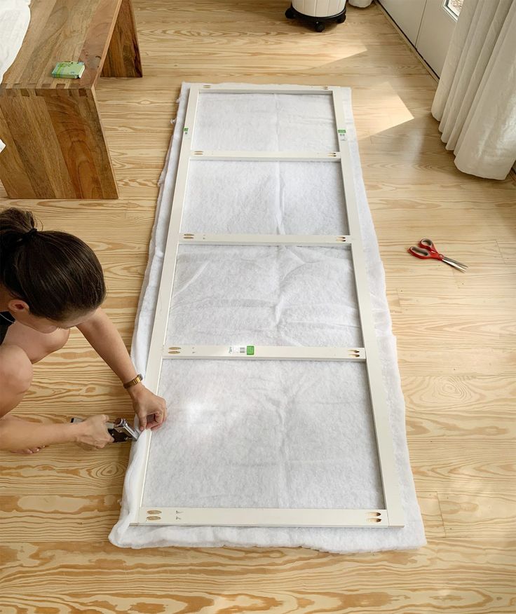 a woman laying on the floor next to a mattress with tape and scissors in it