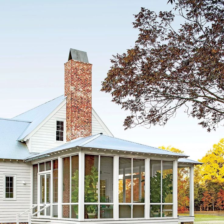 a white house sitting on top of a lush green field