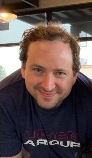 a man sitting at a table smiling for the camera