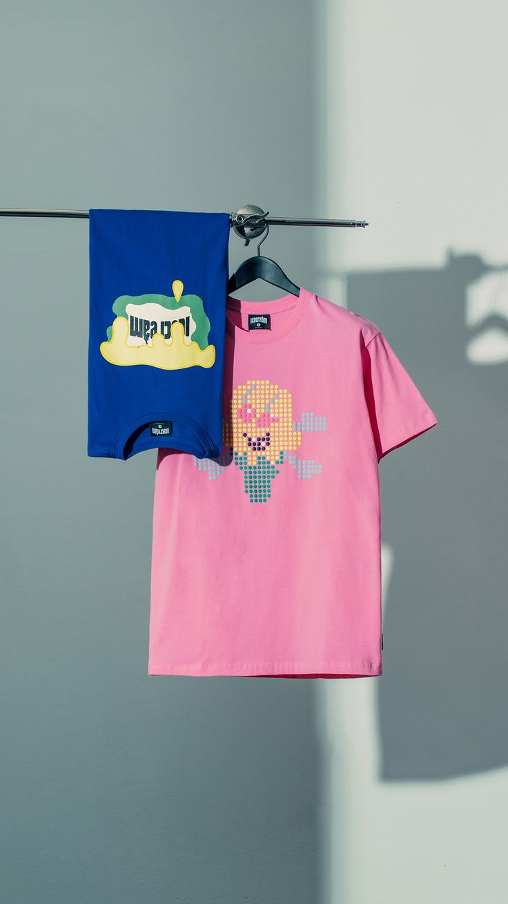 two children's t - shirts hanging on clothes line