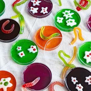 many different colored candies on a white table cloth