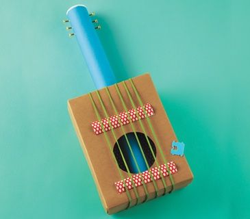 a cardboard box with a blue toothbrush inside on a green surface, top view